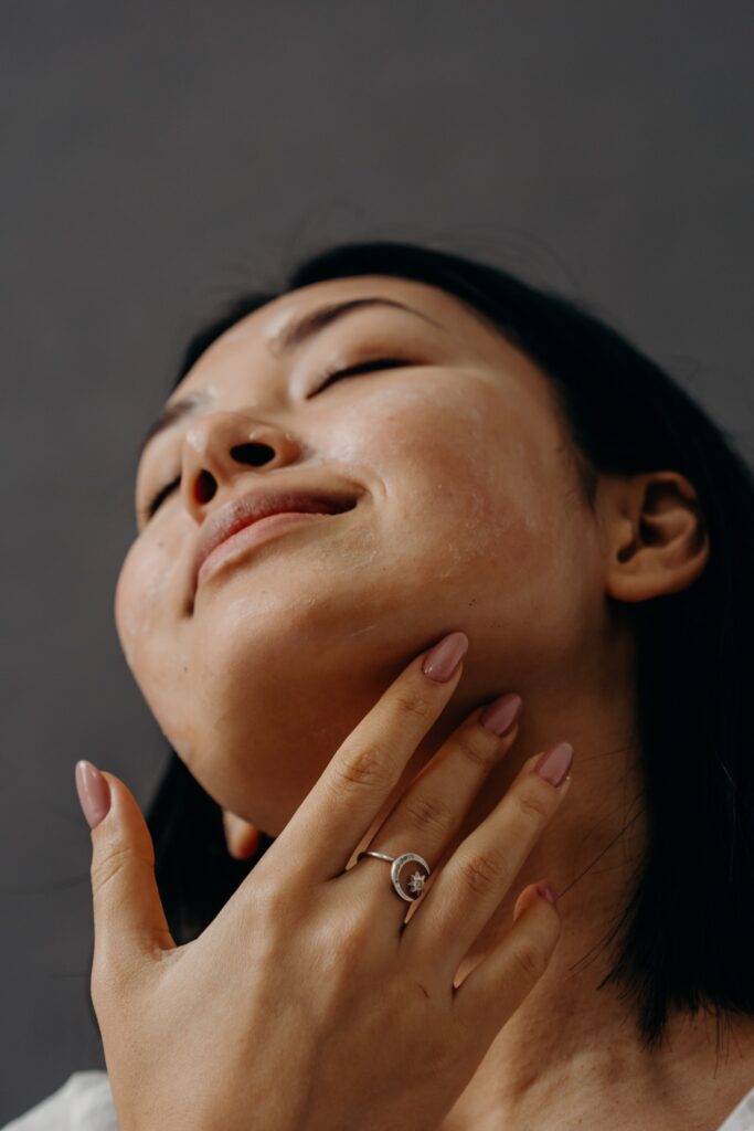 mujer aplicandose crema en el cuello