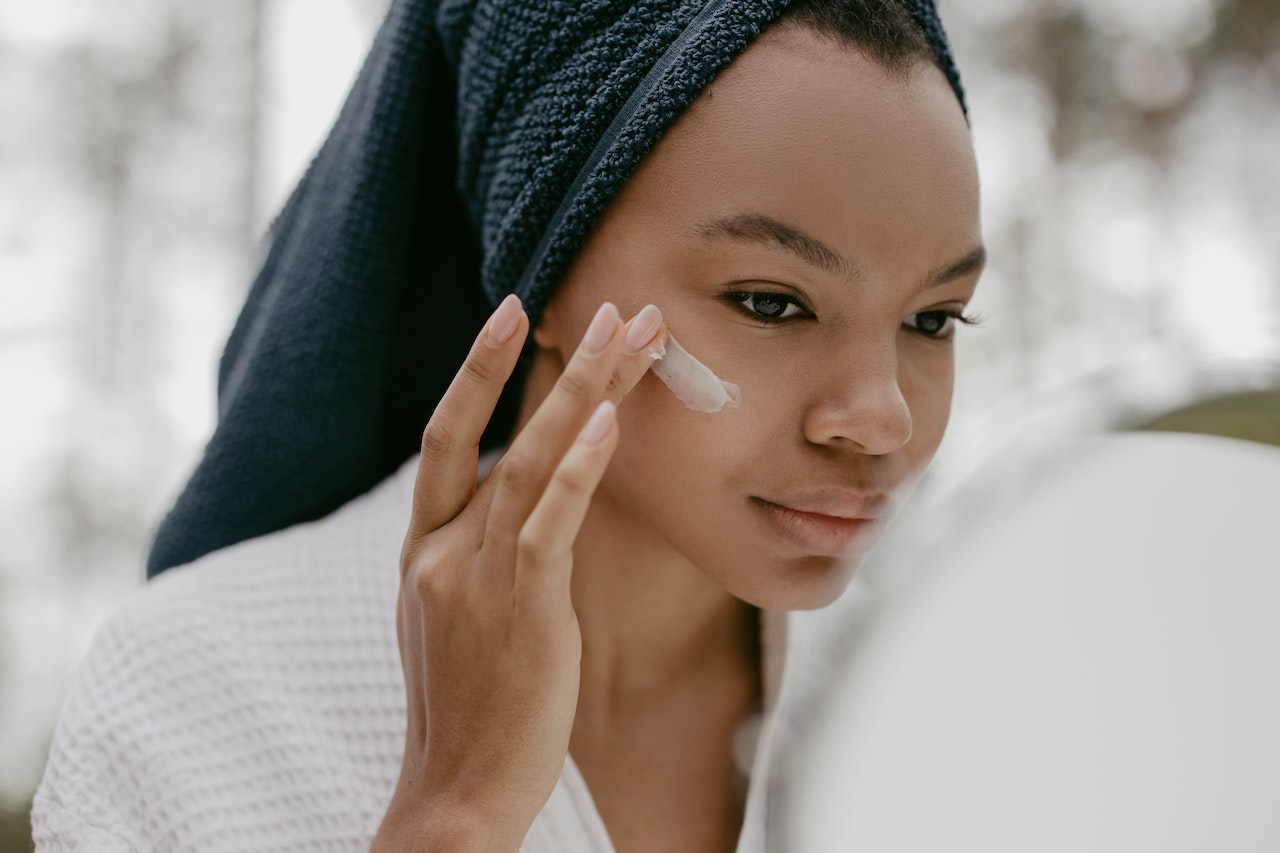 mujer aplicandose crema para prevenir la flacidez facial
