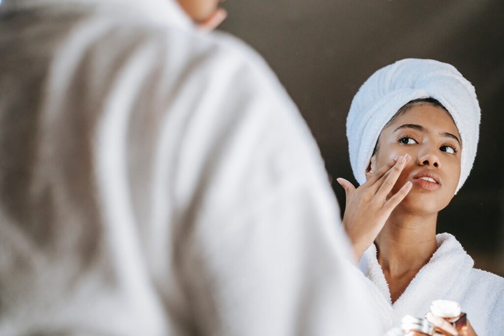 mujer aplicandose crema en la cara para prevenir la flacidez facial
