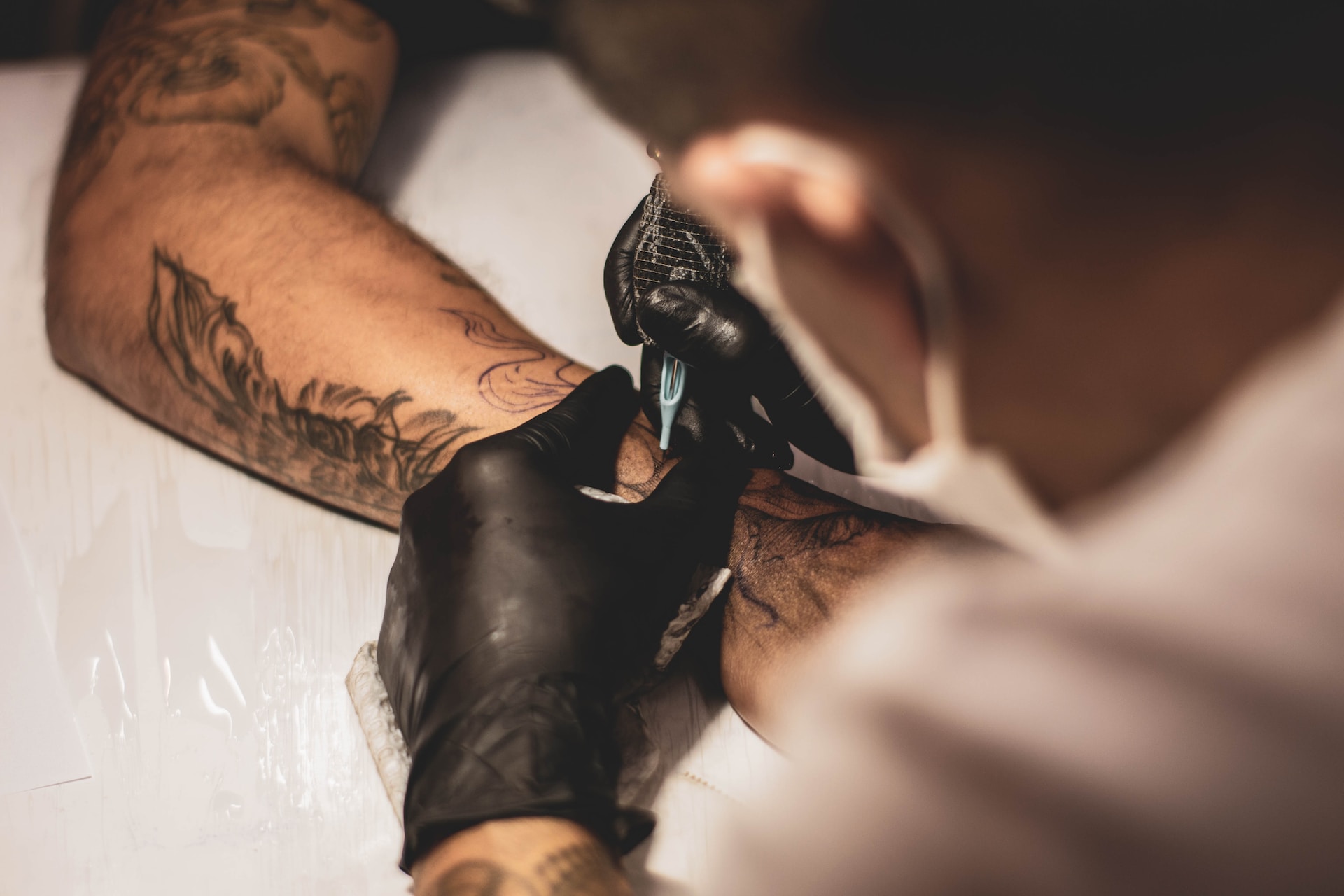 Tatuador tatuando brazo