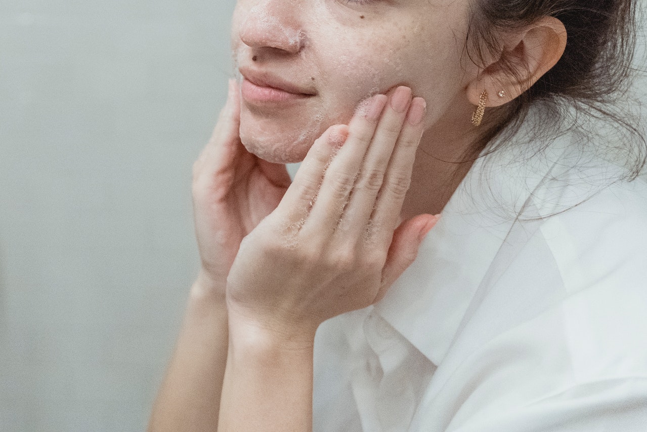 mujer aplicandose una crema facial