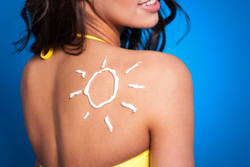 Mujer con protector solar en espalda
